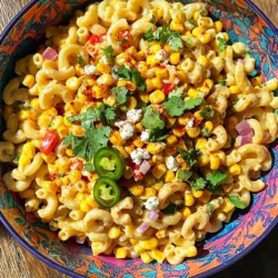 - 2 cups elbow macaroni - 1 cup corn kernels (fresh or frozen) - 1 red bell pepper, diced - 1 jalapeño, finely chopped - 1/2 cup red onion, finely chopped - 1/2 cup cilantro, chopped - 1/2 cup crumbled queso fresco (or feta cheese) - 1/4 cup mayonnaise - 1/4 cup sour cream - 2 tablespoons lime juice - 1 teaspoon chili powder - Salt and pepper to taste To make the Mexican Street Corn Pasta Salad, you need a mix of fresh and bold flavors. First, you need elbow macaroni to form the base. This pasta is perfect for holding all the tasty bits. Next, corn kernels add a sweet crunch. You can use fresh corn or frozen, depending on what you have. The red bell pepper brings a nice color and sweetness. The jalapeño adds a bit of heat, but you can adjust it based on your taste. Chop up some red onion for a sharp flavor that contrasts with the sweet corn. For a fresh touch, use cilantro, which gives it a bright, herbal flavor. For creaminess, mix in crumbled queso fresco or feta cheese. This cheese adds a salty bite that works well with the other ingredients. Combine mayonnaise and sour cream for a rich dressing. Add lime juice for a tangy kick. Finally, use chili powder and salt and pepper to bring everything together. This combination of ingredients creates a delightful salad that is both simple and full of flavor. - First, cook 2 cups of elbow macaroni until al dente. - Drain it well and rinse under cold water to cool. Set it aside. - Next, heat a large skillet over medium heat. - Add 1 cup of corn kernels and sauté until golden and slightly charred, about 5 to 7 minutes. - Once done, take the skillet off the heat and let the corn cool down. - In a large mixing bowl, mix the cooled pasta, charred corn, and fresh diced vegetables. - These include 1 diced red bell pepper, 1 finely chopped jalapeño, and 1/2 cup of finely chopped red onion. - In a smaller bowl, whisk together the dressing. Combine 1/4 cup mayonnaise, 1/4 cup sour cream, 2 tablespoons of lime juice, and 1 teaspoon of chili powder. - Season with salt and pepper to taste. - Pour this dressing over the pasta salad and gently toss until everything is coated. - Finally, fold in 1/2 cup of chopped cilantro and 1/2 cup of crumbled queso fresco. Mix until well combined. You can change the heat level by adjusting the jalapeño. If you like it spicier, add more jalapeño. If you want it milder, use less or skip it. You can also swap out the cheese. Try feta or any cheese you enjoy. This adds a twist to the salad and keeps it fresh. Serve your salad in colorful bowls or individual cups. This makes it look fun and inviting. Top it off with chili powder and fresh cilantro for a pop of color. It not only looks great but also adds extra flavor. This pasta salad pairs well with grilled meats or tacos. It’s a great side for summer barbecues. You can also bring it to picnics and potlucks. It travels well and everyone loves it! {{image_2}} You can boost this salad by adding protein. Grilled chicken or shrimp works well. Just chop it into bite-sized pieces and mix it in. If you're vegetarian, black beans are a great choice. They add protein and a nice texture. Seasonal ingredients can make this salad shine. Try adding diced avocado for creaminess. Other seasonal veggies like zucchini or cherry tomatoes can add color and flavor too. You can also mix it up by using different types of pasta, like rotini or penne. Want to kick up the flavor? A splash of hot sauce can add heat. You can also squeeze in more lime juice for a zesty twist. For some crunch, try adding toasted nuts like almonds or pecans. It gives the salad a nice texture and depth of flavor. Store your Mexican Street Corn Pasta Salad in an airtight container. It stays fresh for up to 3 days. I find it tastes best when served chilled. The coolness enhances the flavors. Freezing this salad is not a good idea. The pasta gets mushy and loses its texture. Instead, you can prepare the dressing separately. This way, you can enjoy fresh flavors later. This salad is perfect cold. If you want to reheat, do it gently. Use low heat to warm it up without cooking it again. The goal is to keep it fresh and tasty. Mexican Street Corn Pasta Salad is a vibrant and tasty dish. It combines pasta, sweet corn, and fresh veggies. Key flavors include lime, chili powder, and creamy dressing. The corn gets a nice char that adds depth. Fresh cilantro and queso fresco bring extra brightness. This dish is perfect for summer gatherings or picnics. Yes, you can make this salad ahead of time. It actually tastes better when you let the flavors meld. I recommend chilling it for at least 30 minutes. This time helps the pasta soak up the dressing. You can prepare it the night before for easy serving. To make this recipe gluten-free, just substitute gluten-free pasta. Many brands offer great options that cook well. The rest of the ingredients are naturally gluten-free. This way, everyone can enjoy this delicious salad. To make this salad vegan, replace dairy ingredients with plant-based alternatives. Use vegan mayo and plant-based sour cream. You can also swap queso fresco for a vegan cheese. This keeps the creamy texture while making it suitable for vegans. Enjoy all the flavors without compromise! This recipe gives you a bright and tasty Mexican Street Corn Pasta Salad. You learned the main ingredients, cooking steps, and tips for flavor. You can customize it to fit your taste. Remember, store leftovers in the fridge for up to three days. Enjoy serving this salad at your next meal or gathering. It's a simple dish that brings fresh flavors and fun to any table. Dive in and make it your own!