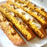 To make pumpkin spice biscotti, you need some key ingredients. Here’s what you will use: - 2 cups all-purpose flour - 1 teaspoon baking powder - 1 teaspoon ground cinnamon - 1 teaspoon ground nutmeg - 1/2 teaspoon ground ginger - 1/4 teaspoon ground cloves - 1/4 teaspoon salt - 3/4 cup granulated sugar - 1/4 cup packed brown sugar - 1/2 cup pumpkin puree - 2 large eggs - 1 teaspoon vanilla extract Each ingredient plays an important role. The flour gives the biscotti structure. The baking powder helps them rise. The spices add warmth, while the sugars balance the flavors. Pumpkin puree makes them moist and adds that lovely fall taste. You can add some fun extras if you like: - 1/2 cup chopped walnuts or pecans - 1/4 cup white chocolate chips Adding nuts gives a nice crunch. White chocolate adds sweetness and creaminess. Feel free to mix and match these options to make the biscotti your own! First, preheat your oven to 350°F (175°C). While it heats, line a baking sheet with parchment paper. This keeps the biscotti from sticking and makes cleanup easy. Next, gather a medium bowl. In this bowl, whisk together the following dry ingredients: - 2 cups all-purpose flour - 1 teaspoon baking powder - 1 teaspoon ground cinnamon - 1 teaspoon ground nutmeg - 1/2 teaspoon ground ginger - 1/4 teaspoon ground cloves - 1/4 teaspoon salt Set this bowl aside. We will mix the dry ingredients with the wet ones later. Now, grab a large mixing bowl. Combine the following: - 3/4 cup granulated sugar - 1/4 cup packed brown sugar - 1/2 cup pumpkin puree Mix these ingredients until they are smooth and well combined. This step brings out the sweet pumpkin flavor. Next, add in the eggs, one at a time. Mix well after each addition. Finally, stir in 1 teaspoon of vanilla extract. This adds a lovely aroma and depth to our biscotti. It's time to combine the wet and dry mixtures. Gradually add the dry ingredients to the pumpkin mixture. Mix until just combined; be careful not to overmix. If you want, fold in 1/2 cup of chopped walnuts or pecans and 1/4 cup of white chocolate chips. Now, divide the dough in half. Shape each half into a log, about 12 inches long, on the prepared baking sheet. Flatten the tops slightly for even baking. Bake these logs for 25-30 minutes, or until they are slightly firm and lightly golden. Remove them from the oven and let them cool for about 10 minutes. After cooling, use a serrated knife to slice the logs diagonally into 1-inch wide pieces. Lay the slices cut-side down back onto the baking sheet. Now, it's time for the final bake. Bake the biscotti for an additional 10-15 minutes. Turn them halfway through to ensure they are crisp and golden on both sides. After this bake, let the biscotti cool completely on a wire rack before enjoying them or storing them. To make perfect pumpkin spice biscotti, texture is key. You want your biscotti to be crunchy but not too hard. To achieve this, mix your dough until just combined. Overmixing can lead to tough biscotti. After your first bake, let the logs cool for about 10 minutes. This helps them firm up but stay soft enough for slicing. Use a serrated knife to cut them. This knife helps to slice through the crunchy crust easily. When you bake the sliced biscotti again, keep an eye on the time. You want them golden and crisp, so check them halfway. Turn them to ensure even baking on both sides. Serving your biscotti can be a fun part! Arrange them in a festive container or on a nice platter. It adds charm to your table. For an extra touch of sweetness, drizzle melted white chocolate over the top. This not only looks pretty but adds a creamy contrast to the spices. You can also sprinkle a few crushed nuts on top for added texture. With these tips, your pumpkin spice biscotti will impress everyone! {{image_2}} You can change the spices in your pumpkin spice biscotti. Try adding allspice or cardamom for a new twist. You can also add a bit of orange zest for a bright, fresh flavor. This gives your biscotti a fun fall vibe. Seasonal flavors are great too. Use maple syrup instead of some sugar for a sweet touch. You could even mix in a bit of apple pie spice for a cozy feel. When it comes to nuts, you can choose almonds or pecans. Both add a nice crunch. Almonds have a mild flavor, while pecans are sweet and buttery. If you can't choose, mix them! A blend of nuts can really enhance the taste. Just make sure to chop them well so they mix in nicely. Chocolate can make your biscotti even more special. You might pick dark chocolate for a rich taste. It pairs well with the pumpkin and spices. White chocolate, on the other hand, adds sweetness and creaminess. If you prefer no chocolate, that’s fine too! The biscotti will still be tasty. You can enjoy them plain or dipped in coffee. To keep your pumpkin spice biscotti fresh for a week, store them in an airtight container. This helps to lock in their flavor and crunch. Place the biscotti in a single layer if possible. If you stack them, put parchment paper between layers. This way, they won't get soft or lose their shape. If you want to keep biscotti for longer, freezing is a great option. Wrap each piece tightly in plastic wrap. Then, place them in a freezer-safe bag or container. This method keeps the biscotti fresh for up to three months. When you're ready to enjoy them, take the biscotti out of the freezer. Let them thaw at room temperature for about an hour. You can also warm them in the oven at a low temperature for a few minutes. This will bring back their crispiness and make them taste freshly baked. The best way to serve pumpkin spice biscotti is with coffee or hot tea. The warm drinks help soften the biscotti, making each bite even better. You can also arrange them on a pretty plate. Drizzling warm white chocolate on top adds a nice touch. For a fall-themed treat, place biscotti in a festive basket or jar. You can use fresh pumpkin instead of pumpkin puree. Just cook and mash the pumpkin until smooth. Be sure to drain any extra moisture, as it can change the dough’s texture. Fresh pumpkin adds a nice flavor, but store-bought puree is still great for convenience. Homemade biscotti can last up to two weeks when stored in an airtight container. Keep them in a cool, dry place. For longer storage, consider freezing them. They still taste great when thawed, making them perfect for later enjoyment. Yes, you can make these biscotti gluten-free. Use a gluten-free flour blend in place of all-purpose flour. Ensure that other ingredients, like baking powder, are also gluten-free. The taste and texture may differ slightly, but the flavors will still shine through! Making pumpkin spice biscotti is fun and easy. We covered the essential ingredients needed, like flour and pumpkin puree. I shared step-by-step instructions to create the perfect biscotti, from mixing to baking. Using tips for texture and presentation will impress your family and friends. You can explore various flavors and storage options for long-lasting treats. Enjoy your homemade biscotti, and let your creativity shine! Each bite brings cozy, autumn comfort to your day.
