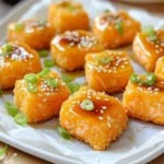 To make crispy honey garlic salmon bites, gather these key items: - 1 lb salmon fillet, skinless and cut into bite-sized cubes - ½ cup cornstarch - ½ teaspoon salt - ¼ teaspoon black pepper - 1 cup vegetable oil (for frying) - ¼ cup honey - 2 tablespoons soy sauce (low sodium) - 2 cloves garlic, minced - 1 teaspoon ginger, minced You will need a few basic tools to cook this dish: - Large non-stick skillet - Small saucepan - Mixing bowl - Paper towels - Serving bowl To make your dish look nice and add flavor, consider these garnishes: - 1 green onion, thinly sliced - Sesame seeds First, gather your salmon fillet. Cut it into bite-sized cubes. You want them to be even in size. This helps them cook evenly. In a bowl, mix cornstarch, salt, and black pepper. Toss the salmon cubes in this mixture. Make sure each piece is well-coated. This coating gives the salmon a nice crunch when fried. Next, heat vegetable oil in a large non-stick skillet. Set the heat to medium-high. Once the oil is hot, carefully add the salmon bites. Place them in a single layer. Fry the salmon for about 2-3 minutes on each side. Look for a golden brown color. This means they are crispy. After frying, remove the salmon and place them on a paper towel-lined plate. This step drains excess oil and keeps them crispy. While the salmon cools, prepare the honey garlic sauce. In a small saucepan, mix honey, soy sauce, minced garlic, and ginger. Heat it over low heat. Stir occasionally until it warms up and thickens slightly. This should take about 2-3 minutes. Once the salmon bites are crispy, transfer them to a serving bowl. Drizzle the warm honey garlic sauce over them. Toss gently to coat each piece. Finally, garnish with sliced green onions and a sprinkle of sesame seeds for an extra touch. To get those salmon bites crispy, start with dry salmon. Pat it with a paper towel. This helps the cornstarch stick better. Use cornstarch, not flour. It gives a lighter crunch. Heat your oil well before adding the salmon. If the oil is too cold, the salmon will absorb it and get soggy. Fry in batches. Don’t crowd the pan to keep the heat steady. This way, you’ll get a nice golden color on every bite. To boost flavor, try adding a pinch of chili flakes to the sauce. This adds a nice kick. You can also switch the soy sauce for teriyaki sauce if you like a sweeter taste. Fresh herbs like cilantro or basil can add a fragrant touch. For a tangy twist, mix in a splash of lime juice right before serving. This will brighten all the flavors in your dish. Serve the salmon bites hot for the best taste. Lay them on a platter lined with parchment paper. This keeps them looking nice and helps with cleanup. Add a small bowl of extra honey garlic sauce for dipping. It’s great for those who want more flavor. Pair these bites with a side of steamed veggies or a fresh salad. It balances the meal and adds color to your plate. Enjoy your culinary creation! {{image_2}} If you like heat, try adding some spice. Mix in red pepper flakes or sriracha into the honey garlic sauce. Start with a pinch of red pepper flakes. Taste it before adding more heat. You can also use spicy soy sauce for an extra kick. This twist gives your salmon bites a whole new flavor. You can bake these salmon bites if you want a healthier option. Preheat your oven to 400°F. Line a baking sheet with parchment paper. Place the coated salmon bites on the sheet in a single layer. Bake for 12 to 15 minutes until golden brown. This method keeps the bites crispy without the oil. Frying gives a richer flavor and crunch, but baking is simple and fast. Choose based on your mood or health goals. Both methods work well for delicious salmon bites. You can easily swap some ingredients. If you don’t have cornstarch, use flour instead. It still gives a nice crisp. For a different flavor, try maple syrup instead of honey. Soy sauce can be replaced with tamari for a gluten-free option. Feel free to adjust the garlic and ginger to your taste. More garlic gives a stronger flavor, while less keeps it mild. These swaps can make your dish unique and fit your needs. To store your crispy honey garlic salmon bites, let them cool first. Place them in an airtight container. Store them in the fridge for up to three days. Make sure to keep the sauce separate to prevent sogginess. When you are ready to eat the leftovers, reheat them in a skillet. Heat the skillet over medium heat. Add a little oil for extra crispiness. Cook the salmon bites for about 2-3 minutes on each side. This way, they stay crispy and delicious. You can also use the microwave, but the texture may not be as good. If you want to freeze them, place the cooled salmon bites in a single layer on a baking sheet. Freeze them for about an hour until firm. Then transfer the bites to a freezer-safe bag. They can last for up to three months in the freezer. To enjoy, thaw them in the fridge overnight and reheat as mentioned above. Yes, you can use frozen salmon. Just make sure to thaw it first. Thawing helps the salmon cook evenly. To thaw, place it in the fridge overnight. You can also use cold water for a quick thaw. Just put the sealed salmon in cold water for about an hour. After thawing, pat it dry. This way, the cornstarch will stick better. I love serving salmon bites with fresh sides. Here are some great options: - Steamed broccoli - Rice or quinoa - Salad with a light dressing - Sweet potato fries - Garlic bread These sides add balance and color to your meal. They also complement the sweet and savory flavors of the salmon. Cooking times can change based on the cut. For thicker cuts, increase the frying time. For thinner pieces, reduce the time. Always aim for a golden brown color. Check the doneness by cutting into a piece. Salmon should flake easily but remain moist. If you’re using a whole fillet, it will take longer than bite-sized pieces. Cut pieces cook faster, about 2-3 minutes per side. You learned how to make crispy salmon bites from this guide. We covered key ingredients, step-by-step cooking methods, and helpful tips. You now know about variations and how to store leftovers. As you try these recipes, focus on your taste. Each bite can be a tasty adventure. Enjoy your cooking, and share your experiences with others!
