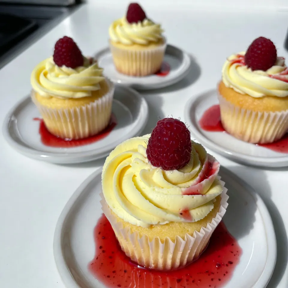 - 1 ½ cups all-purpose flour - 1 teaspoon baking powder - ½ teaspoon baking soda - ¼ teaspoon salt - ½ cup unsalted butter, softened - 1 cup granulated sugar - 2 large eggs - Zest of 1 lemon - 1 teaspoon vanilla extract - ½ cup buttermilk - ½ cup fresh raspberries, plus extra for garnish - 1 tablespoon lemon juice Each ingredient plays a key role in creating the perfect Raspberry Lemonade Cupcakes. All-purpose flour provides the structure. It gives the cupcakes a nice rise and texture. Baking powder and baking soda are essential for leavening. They help the cupcakes rise and stay light. Salt enhances the flavors. Just a pinch makes a big difference, balancing the sweetness. Unsalted butter adds richness and moisture. Soften it first for easy mixing. Granulated sugar sweetens the batter. It also helps to cream with butter for a fluffy mix. Eggs bind the ingredients. They add moisture and support the rise. Lemon zest gives a bright, fresh flavor. It adds a nice citrusy note that pairs well with raspberries. Vanilla extract brings warmth and depth. It complements the lemon and raspberry flavors perfectly. Buttermilk keeps the cupcakes moist. It adds a slight tang that enhances the lemon. Fresh raspberries are the star of the show. They give bursts of flavor in every bite. Lemon juice adds brightness. It enhances the lemon flavor and keeps the cupcakes tangy. Lastly, think about garnish options like fresh raspberries. They add color and a fun touch to your cupcakes. You can even drizzle raspberry sauce around the cupcakes for a fancy look. {{ingredient_image_1}} First, preheat your oven to 350°F (175°C). This step is key to getting your cupcakes fluffy. While the oven warms up, line a cupcake pan with paper liners. This helps the cupcakes come out easily and makes cleanup a breeze. Next, grab a mixing bowl. Whisk together 1 ½ cups of all-purpose flour, 1 teaspoon of baking powder, ½ teaspoon of baking soda, and ¼ teaspoon of salt. Mixing these dry ingredients well ensures your cupcakes rise evenly and taste great. In a large bowl, cream together ½ cup of softened unsalted butter and 1 cup of granulated sugar. Use an electric mixer for about 3-4 minutes until it's light and fluffy. Then, add in 2 large eggs one at a time. Next, mix in the zest of 1 lemon and 1 teaspoon of vanilla extract until just combined. This gives your cupcakes a lovely flavor. Now it’s time to combine the mixtures. Gradually add the dry ingredients to the wet mixture. Alternate with ½ cup of buttermilk and 1 tablespoon of lemon juice. Start and end with the flour mixture. Mix until just combined to keep the cupcakes light. Finally, gently fold in ½ cup of fresh raspberries. Be careful not to break them up too much. Divide the batter evenly among your cupcake liners. Fill each liner about two-thirds full. Bake in your preheated oven for 18-20 minutes. To check if they are done, insert a toothpick into the center. If it comes out clean, they are ready! Once baked, remove the cupcakes from the oven. Let them cool in the pan for 5 minutes. Then, transfer them to a wire rack to cool completely. This helps them stay fluffy and moist. To make great Raspberry Lemonade Cupcakes, you must avoid overmixing. When mixing the batter, stop as soon as the ingredients blend. This keeps cupcakes light and fluffy. Even baking is key. Place the cupcake pan in the center of the oven. This helps heat circulate evenly. Rotate the pan halfway through baking for the best results. I recommend using a lemon buttercream frosting. It complements the tangy flavor of the cupcakes. The creaminess balances the tartness of the raspberries. You can make it by beating softened butter and powdered sugar with lemon juice and zest. For a stunning finish, garnish each cupcake with a fresh raspberry. This adds color and freshness. Consider drizzling raspberry sauce around the cupcakes on the plate. It looks lovely and adds extra flavor. Pro Tips Use Fresh Raspberries: For the best flavor and texture, use fresh raspberries instead of frozen. This will ensure your cupcakes have a vibrant color and a burst of flavor in every bite. Room Temperature Ingredients: Make sure all your ingredients, especially butter and eggs, are at room temperature. This helps create a smoother batter and gives cupcakes a better rise. Don't Overmix: When combining the wet and dry ingredients, mix until just combined. Overmixing can lead to dense cupcakes, so be gentle when folding in the raspberries as well. Check for Doneness: Use a toothpick to test for doneness; insert it into the center of a cupcake and if it comes out clean or with a few crumbs, they are ready. Avoid opening the oven too early to prevent them from sinking. {{image_2}} For a vegan version, swap butter with coconut oil or vegan butter. Use flax eggs instead of regular eggs. To make a flax egg, mix 1 tablespoon of ground flaxseed with 2.5 tablespoons of water. Let it sit for 5 minutes. This mixture works well in baking. To make these cupcakes gluten-free, replace all-purpose flour with a gluten-free blend. Look for a mix that contains xanthan gum for better texture. Almond flour or coconut flour can also work, but adjust the liquid to avoid dryness. Get creative with flavors! You can use strawberries, blueberries, or blackberries instead of raspberries. Add a teaspoon of almond extract for a nutty twist. For a tropical flair, try adding pineapple or mango puree to the batter. You can also mix in lemon curd for extra zing! Store your raspberry lemonade cupcakes at room temperature for the best taste. Place them in an airtight container to keep them fresh. This method helps maintain their soft texture and bright flavor. If you plan to eat them in a few days, room temp is perfect. Avoid placing them in the fridge, as cold air can dry them out. If you have leftover cupcakes after a few days, you might want to refrigerate them. Just be sure to wrap them well in plastic wrap before placing them in the fridge. This prevents them from absorbing any other odors. Freezing your raspberry lemonade cupcakes is easy and a great way to save them for later. Here’s how to do it: - Cool Completely: Let the cupcakes cool fully on a wire rack. - Wrap: Wrap each cupcake in plastic wrap or foil to keep them fresh. - Storage: Place the wrapped cupcakes in a freezer-safe bag or container. To thaw, simply remove the cupcakes from the freezer and let them sit at room temperature for about an hour. If you want to frost them later, you can frost them after thawing. Enjoy your tasty treat anytime! To check if your cupcakes are done, use a toothpick. Insert it into the center of a cupcake. If it comes out clean, they are ready. You can also gently press the top. If it springs back, they are done. Avoid opening the oven too soon. This helps keep the heat inside. Yes, you can use frozen raspberries. However, they may change the cupcake's texture. Frozen berries can break down more than fresh ones. This can make the batter a bit mushy. If you use frozen raspberries, add them directly from the freezer. Do not thaw them first to reduce juice in the batter. To keep your cupcakes moist, use buttermilk. It adds richness and flavor. Also, do not overmix your batter. Mix until just combined to keep air pockets. You can also add an extra egg yolk. This helps create a softer texture. Lastly, avoid baking them for too long. If you do not have buttermilk, you can make a substitute. Mix one tablespoon of lemon juice or vinegar with one cup of milk. Let it sit for five minutes to curdle. You can also use plain yogurt or sour cream. Thin them with a little milk to match buttermilk's consistency. In this blog post, we explored all the key steps to make delicious raspberry lemon cupcakes. We covered ingredients, detailed baking instructions, and helpful tips to ensure perfect results. Remember, the balance of flavors and moisture is crucial for great cupcakes. Whether you go vegan or gluten-free, you can still enjoy this treat. With these techniques, you can impress friends and family. Now, get in the kitchen and start baking! Your sweet creation awaits.