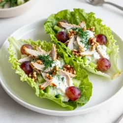 - 2 cups cooked chicken breast, shredded - 1 cup plain Greek yogurt - 1/4 cup celery, finely chopped - 1/4 cup red grapes, halved - 1/4 cup walnuts, roughly chopped - 2 tablespoons fresh dill, chopped - 1 tablespoon lemon juice - Salt and pepper to taste - 1 head of butter lettuce or romaine, leaves separated This recipe packs a punch of nutrients. Greek yogurt is rich in protein and probiotics. It helps with digestion and builds strong muscles. Chicken breast is lean and full of protein. It aids in muscle repair and keeps you full longer. Celery adds fiber while being low in calories. It helps keep your heart healthy. Red grapes give natural sweetness and antioxidants. They help fight free radicals in the body. Walnuts provide healthy fats and omega-3s. They support brain health and reduce inflammation. Fresh dill adds flavor and has anti-bacterial properties. Lemon juice boosts vitamin C, which helps your immune system. When picking chicken, choose fresh or properly frozen breasts. Look for ones that are firm and pink. Avoid any that have a gray tint. For Greek yogurt, select plain varieties. Check for live cultures on the label for the best health benefits. Choose celery stalks that are crisp and green. Avoid limp or discolored stalks. Pick grapes that are firm and free from wrinkles. They should have a fresh smell. Select walnuts that are not rancid. They should smell nutty and fresh. For fresh dill, look for bright green fronds without wilting. When buying lettuce, choose heads that are crisp without brown spots. {{ingredient_image_1}} Start by shredding 2 cups of cooked chicken breast. I love using leftover chicken for this. In a mixing bowl, add the shredded chicken and 1 cup of plain Greek yogurt. This yogurt gives a creamy texture and adds protein. Next, chop 1/4 cup of celery finely. Add that to the bowl. Now, take 1/4 cup of red grapes and cut them in half. Toss those in too. Chop 1/4 cup of walnuts roughly and add them for a nice crunch. You can also mix in 2 tablespoons of fresh dill for flavor. Squeeze 1 tablespoon of lemon juice into the mix. This adds a zesty kick. Finally, season with salt and pepper to taste. Mix everything well until combined. Now it's time to assemble the wraps. Take a head of butter lettuce or romaine and separate the leaves. These leaves act as our wrap. Spoon a generous amount of the chicken salad mixture into the center of each leaf. Fold the sides over and gently wrap them around the filling. Make sure to keep it tight but not too tight. Serve immediately for the best crunch and freshness. These wraps are perfect for lunch or a light dinner. You can serve them with fresh veggies or hummus on the side. For a fun twist, try adding a sprinkle of feta cheese on top. If you want a bit of heat, add some sliced jalapeños. You can also serve them on a platter for parties. They look great and taste even better! You can make this chicken salad your own. Try adding different fruits like apples or cranberries. Swap the walnuts for almonds or pecans for a new crunch. If you like spice, add some diced jalapeños or a dash of hot sauce. You could also throw in some chopped green onions for a fresh taste. Remember, the key is to balance flavors and textures to suit your taste. This chicken salad is perfect for meal prep. You can make it a day ahead. Store it in an airtight container in the fridge. Just keep the lettuce leaves separate. The salad will last for about three days. This way, you have a quick meal ready when hunger strikes. You can also portion it into containers for easy grab-and-go lunches. These wraps work well for many events. Serve them at a picnic or barbecue for a light dish. They are great for lunch or a snack too. For a fancy touch, use small lettuce cups to serve at parties. You can also add a side of fruit or a light salad to make it a full meal. Kids love these wraps for an easy, fun meal option. Pro Tips Use Leftover Chicken: This recipe is perfect for utilizing leftover rotisserie or grilled chicken, making it even quicker to prepare. Customize Your Add-ins: Feel free to swap in your favorite nuts, fruits, or herbs to personalize the flavor of your chicken salad. Chill Before Serving: For the best flavor, let the chicken salad chill in the refrigerator for about 30 minutes before serving. Choose Fresh Lettuce: Select crisp, fresh lettuce leaves for wrapping to ensure a satisfying crunch with each bite. {{image_2}} You can make simple swaps for a lighter Greek yogurt chicken salad. Instead of walnuts, try sunflower seeds for crunch. They have less fat and add a nice texture. You can also use low-fat Greek yogurt. This cut cuts calories but keeps the creamy taste. For less sodium, use fresh herbs instead of salt. Fresh dill adds flavor without extra salt. To make a vegetarian version, replace chicken with chickpeas. Use one can of chickpeas, drained and rinsed. Mash them lightly with a fork for a nice texture. Keep all the other ingredients the same. This helps you enjoy the same great taste while keeping it plant-based. You can also add diced apples for a sweet twist. Want to spice things up? Add diced jalapeños for heat. You can also mix in curry powder for a unique flavor. A tiny bit of honey can add sweetness, balancing the tartness of yogurt. For a Mediterranean twist, add feta cheese and olives. Each enhancement brings a new taste to the dish. To keep your Greek yogurt chicken salad fresh, store it in a tight container. Make sure to remove as much air as possible. This helps prevent spoilage. You can also use plastic wrap over the bowl before sealing. This adds an extra layer of protection. Always keep it in the fridge. When stored properly, this chicken salad lasts up to three days in the fridge. After that, the flavors may change, and it may not taste as good. Always check for any off smells or changes in texture before eating. If you don’t think you’ll eat it in three days, freeze it. For this recipe, you don’t need to reheat it. Greek yogurt chicken salad tastes best cold. If you prefer warmed chicken, you can gently heat it in the microwave. Use a low setting to avoid drying it out. Stir it well and check the temperature to ensure it’s warm but not hot. Yes, you can use canned chicken. Canned chicken is already cooked and saves time. Just drain it well before mixing it with Greek yogurt. The taste will still be good, but fresh chicken has a better texture. If you want extra flavor, add some spices or herbs to the canned chicken. To make this dish dairy-free, swap Greek yogurt for a plant-based yogurt. Look for options made from almond, coconut, or soy. Make sure the yogurt is plain and unsweetened. You can add a splash of lemon juice to mimic the tangy taste of yogurt. This keeps the salad creamy while staying dairy-free. Lettuce wraps pair well with many sides. Here are some great ideas: - Fresh veggie sticks (carrots, cucumbers, bell peppers) - A light fruit salad - Quinoa salad with herbs - Sweet potato fries - A simple soup, like tomato or vegetable These sides add color and nutrition to your meal. Enjoy experimenting with different pairings! You learned about the key ingredients for a tasty chicken salad. We explored how to prepare and assemble delicious lettuce wraps. I shared tips for customizing your salad and making it ahead. We also looked at variations, storage tips, and answered common questions. Remember, with the right ingredients and methods, you can create a great meal. Enjoy experimenting with flavors and serving ideas to make it your own. Happy cooking!